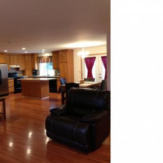 A spacious open-concept kitchen and living area with hardwood floors and modern furnishings.