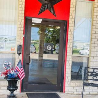 The inviting entrance of a building featuring a prominent red star and decorative elements.