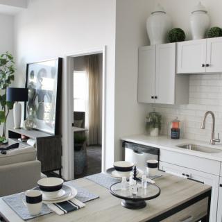 A modern apartment with an open kitchen and dining area, seamlessly connected to the living room.