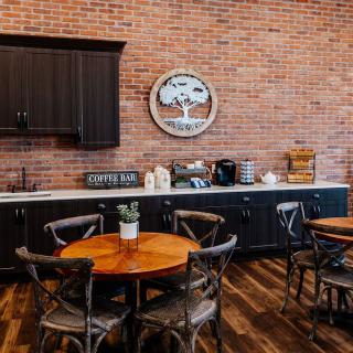 A cozy coffee shop with wooden tables and brick wall decor.