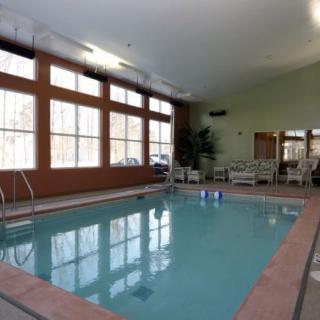 An indoor swimming pool area with large windows and seating.
