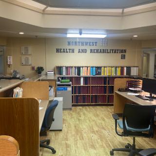 A view of a healthcare rehabilitation office with organized workstations and shelves.