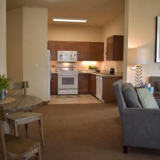 A modern apartment interior with an open kitchen and a cozy living area.
