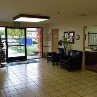 A well-lit lobby area with seating and a view of the outside through glass doors.