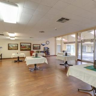 A spacious dining area with several tables and large windows, ideal for community gatherings.