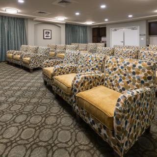 A well-organized seating area with patterned armchairs in a spacious room.