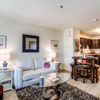 A modern living room with a cozy seating area and open kitchen.