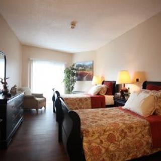 A cozy bedroom with twin beds, elegant decor, and warm lighting.