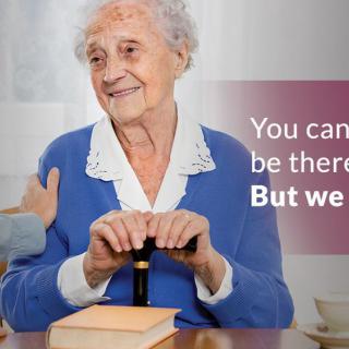An elderly woman smiles while receiving support from a caregiver.
