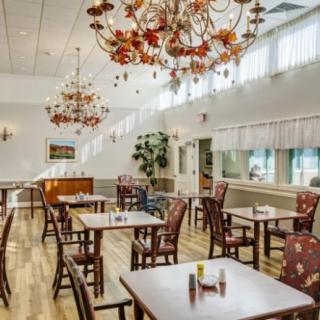 An elegant restaurant dining area with decorative chandeliers and neatly arranged tables.