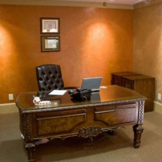 A traditional office setup featuring a wooden desk, a leather chair, and a laptop.