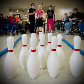 A group of people enjoying an indoor bowling game at a community center.