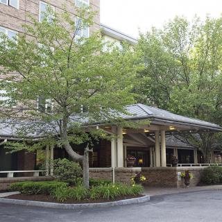A building entrance surrounded by greenery and trees.