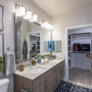 A modern bathroom with a double sink vanity and ample lighting.