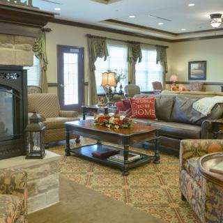A cozy and elegantly furnished living room with a sofa, coffee table, and fireplace.