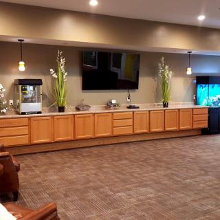 A modern lounge area with wooden cabinetry, decorative plants, and a mounted television.