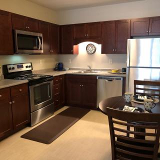 A modern kitchen with stainless steel appliances and wooden cabinets.