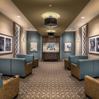 A modern lobby with comfortable seating, stylish chandeliers, and artwork adorning the walls.