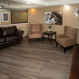 A cozy living room with a sofa, two armchairs, and decorative wall art.