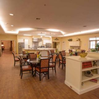 A modern dining area with a view of an open kitchen and elegant furniture.