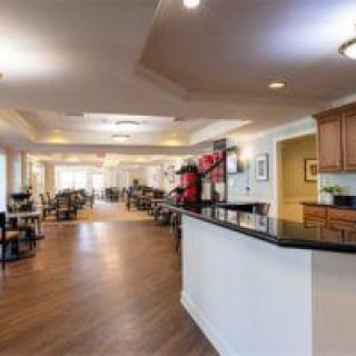A spacious dining area with a modern design featuring a long counter and multiple tables and chairs.