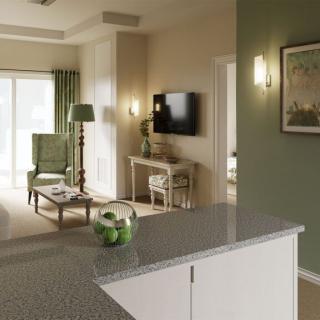 A modern living room with green accents and stylish decor, featuring a TV and comfortable seating.