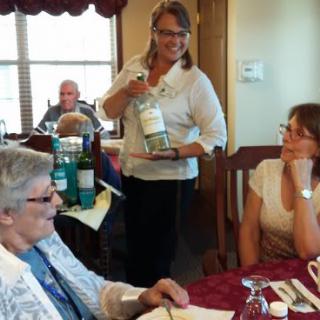 A group of people enjoying a celebration with wine at a restaurant.