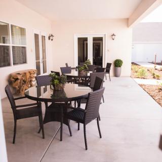 A spacious patio with outdoor seating and a table, set in a garden area.