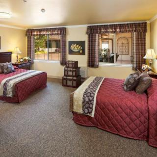 A cozy hotel room with two double beds and warm decor.