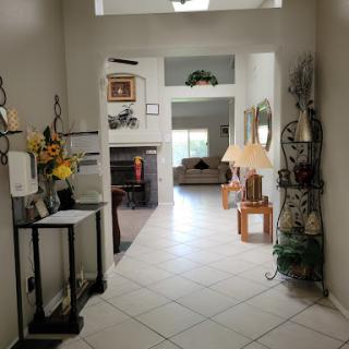 A view of a spacious hallway leading to a cozy living room, adorned with decorative elements and natural light.