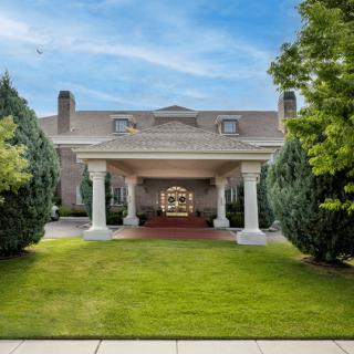 A grand building entrance with columns and well-maintained landscaping.