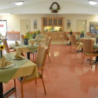 An empty dining area with neatly arranged tables and chairs, featuring a welcoming interior design.