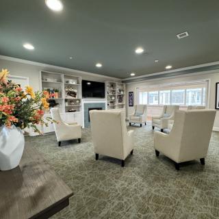 A modern living room with neutral tones, featuring comfortable seating, a fireplace, and built-in bookshelves.