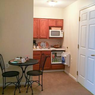 A compact kitchenette with a small dining area in an apartment.