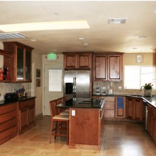 Spacious kitchen with wooden cabinets, modern stainless steel appliances, and an island with seating.