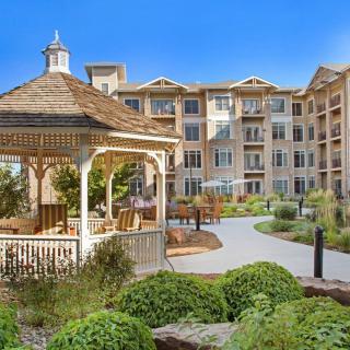 A beautifully landscaped apartment complex with a charming gazebo in the garden.