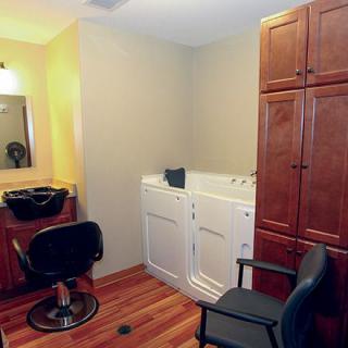 A cozy hair salon setup with chairs, a mirror, and cabinets.