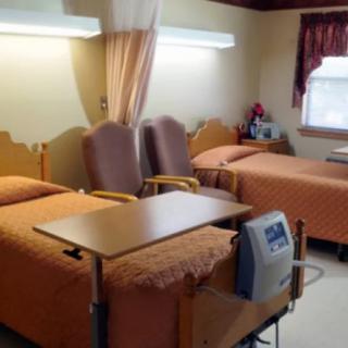 A hospital room with two beds and medical equipment.