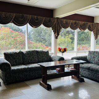 A cozy living room featuring elegant couches, a central coffee table, and large windows adorned with stylish curtains.