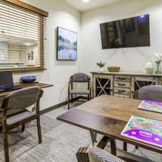 A well-appointed meeting room featuring a wooden table, chairs, a wall-mounted television, and decorative elements.