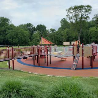 A vibrant playground surrounded by lush greenery, perfect for outdoor fun.