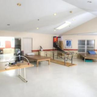 A spacious rehabilitation room equipped with various exercise equipment for physical therapy sessions.