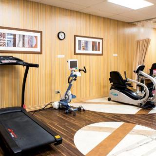 A modern gym with a treadmill, stationary bike, and recumbent bike.