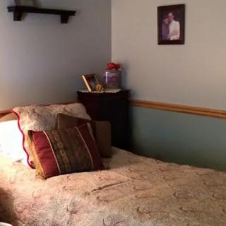 Cozy bedroom with a bed, pillows, and framed photo on the wall.
