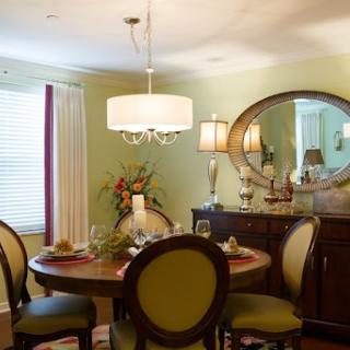 A cozy and elegantly designed dining room featuring a round table, comfortable chairs, and stylish lighting.