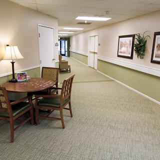 A neat and well-decorated hallway with a table, chairs, and artwork on the walls.