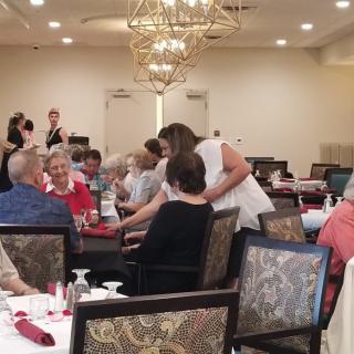 A group of people enjoying a dining event in an elegantly decorated room.