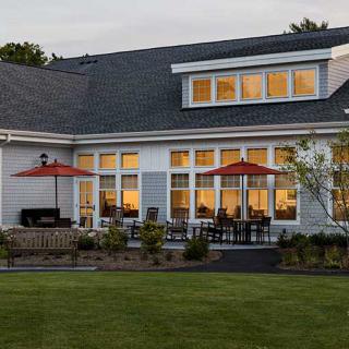 A cozy house with a spacious backyard and patio set in the evening light.