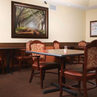 A cozy dining area with elegant chairs and a nature-themed painting on the wall.