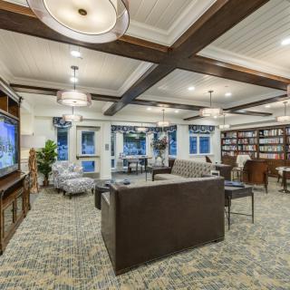A modern living room with a cozy seating area, television, and a small library.